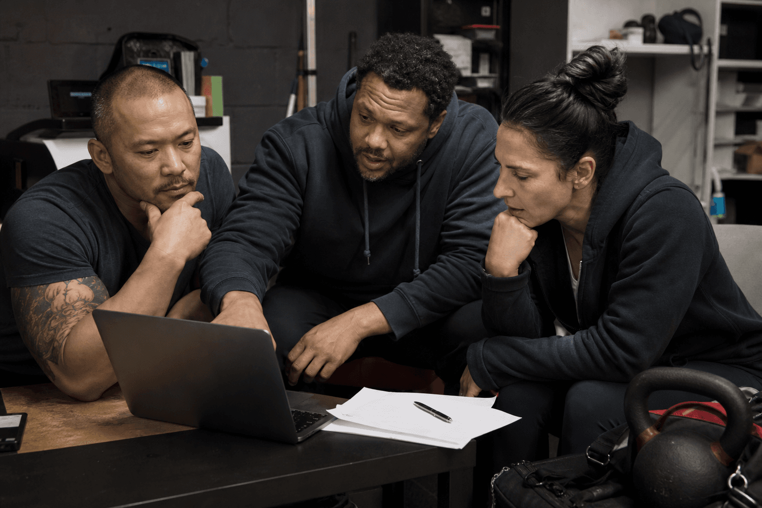 Owner-led operators reviewing workflow handoffs near training gear