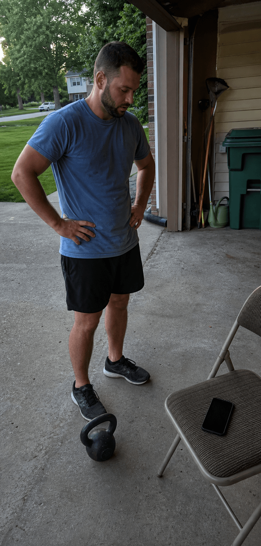 Adult checking a driveway training plan beside a kettlebell